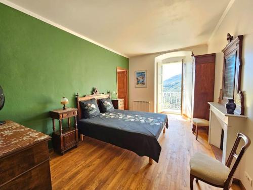 a bedroom with a bed and a green wall at Maison d Americain a Figarella au Cap Corse in Santa-Maria-di-Lota