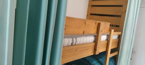 Ce lit superposé se trouve dans un dortoir doté d'un rideau bleu. dans l'établissement Au petit bonheur 2, à Sanary-sur-Mer