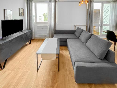 un salon avec un canapé gris et une table dans l'établissement Porte de la Bourgogne à Chalon sur Saône, à Chalon-sur-Saône