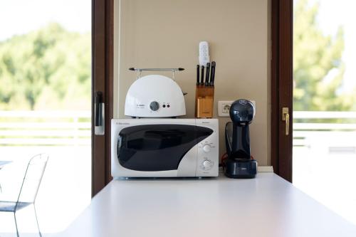 a white microwave sitting on top of a kitchen counter at The Residence Aparthotel in Podstrana