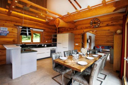 une cuisine et une salle à manger avec une table et des chaises dans l'établissement Original chalet en rondins, l'Ours Canadien, à Xonrupt-Longemer