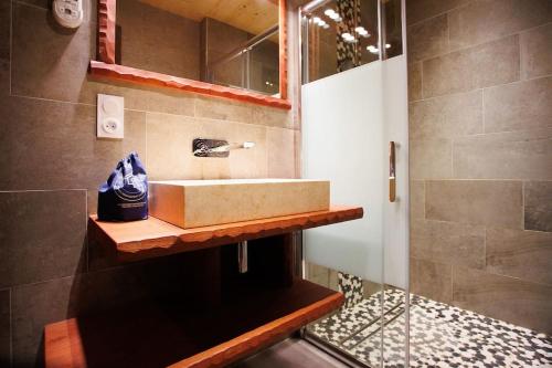 une salle de bain avec un lavabo et un miroir dans l'établissement Original chalet en rondins, l'Ours Canadien, à Xonrupt-Longemer