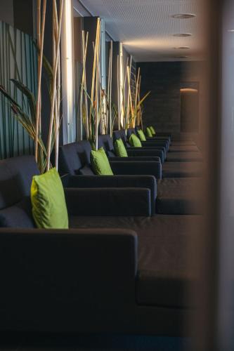a row of blue couches with green pillows at Ritzenhof - Hotel und Spa am See 4-Sterne-Superior in Saalfelden am Steinernen Meer