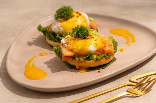 芭东海滩Eden Resort & Villas Phuket Patong的一盘夹着鸡蛋和西兰花的三明治