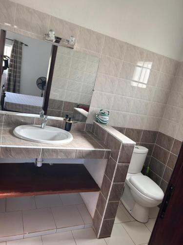 a bathroom with a sink and a toilet at RELAX PARC Mboro in Mboro