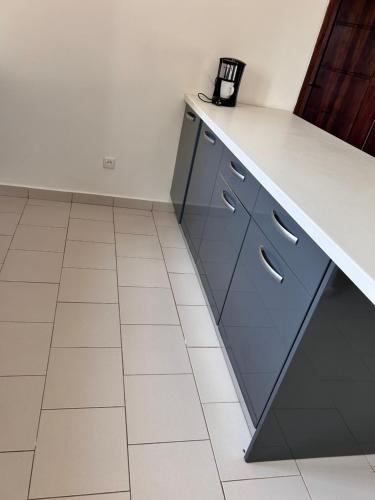 a kitchen with blue cabinets and a white counter top at RELAX PARC Mboro in Mboro