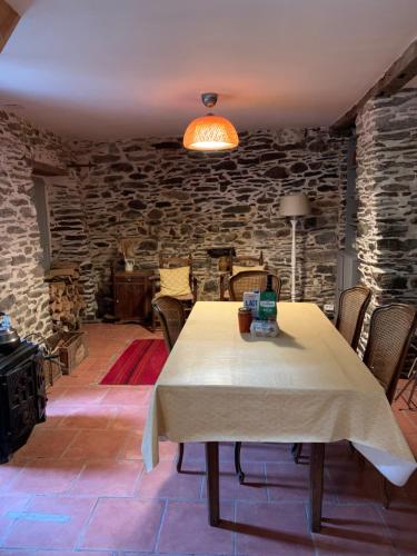 une salle à manger avec une table et un mur en pierre dans l'établissement Havre de paix, à Mas-Cabardès