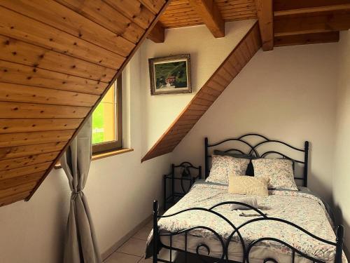 a bedroom with a black bed in a attic at Buhl de Bonheur in Guebwiller