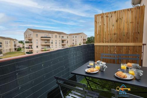 a table on a balcony with food and drinks at Superbe Nid Douillet avec Terrasse, Double Parking in Carcassonne