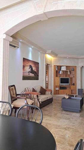 a living room with a couch and a table and chairs at Spacious Apart, 2-min to beach & Old Souk in Jbeil