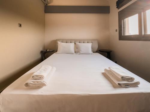 a bedroom with a white bed with towels on it at Villa Nirome xlarge private pool in Vathí