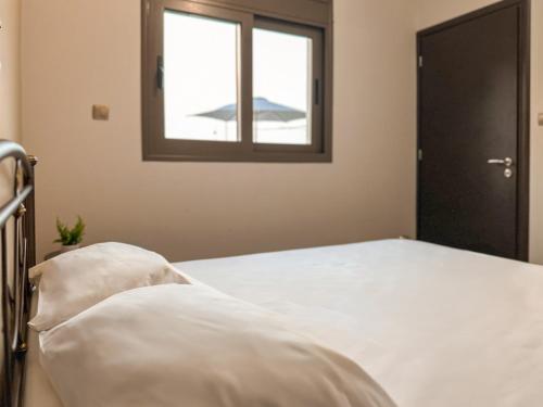 a bedroom with a bed and a window at Villa Nirome xlarge private pool in Vathí