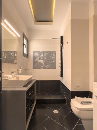 a bathroom with a sink and a toilet at Villa Nirome xlarge private pool in Vathí