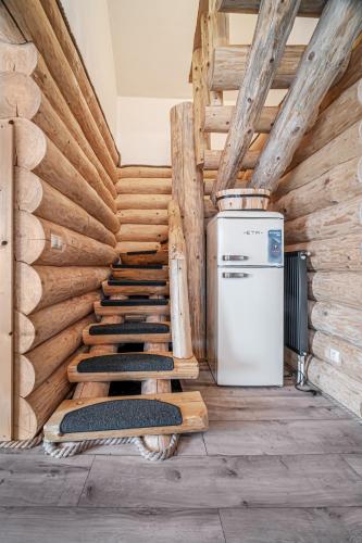 a room with wooden stairs and a refrigerator and a stove at Zrub Šumiac in Šumiac