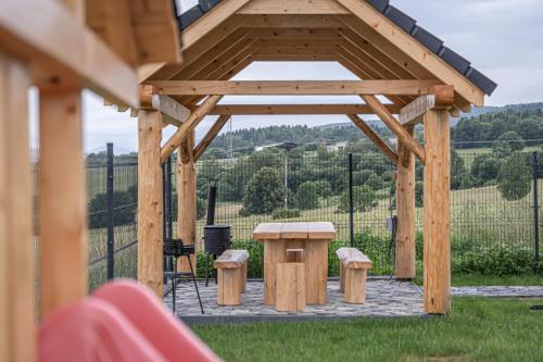 a wooden gazebo with a table and chairs at Zrub Šumiac in Šumiac
