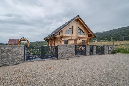 a wooden house with a gate and a fence at Zrub Šumiac in Šumiac