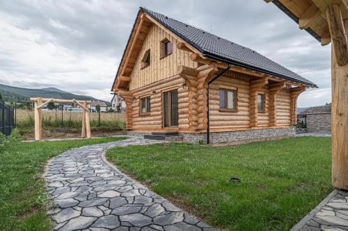 a log cabin with a stone path in front of it at Zrub Šumiac in Šumiac