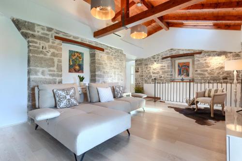 Una sala de estar con un sofá y una pared de piedra. en Beautiful Villa Cartolina with pool in Buje, en Krasica