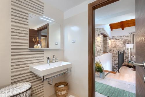 un baño con lavabo y espejo en Beautiful Villa Cartolina with pool in Buje, en Krasica