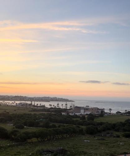 a view of the ocean at sunset at Cozy 2 bedrooms flat at Dar Bouazza in Dar Bouazza