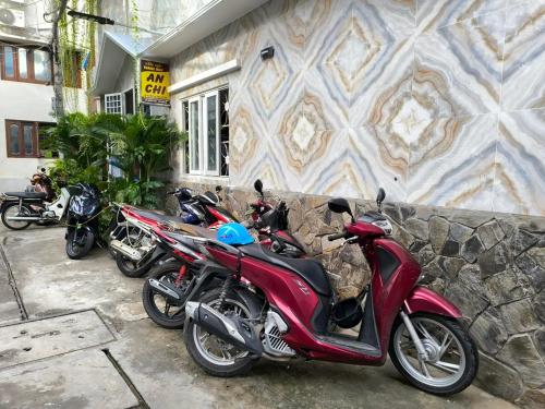 a row of motorcycles parked in front of a building at An Chi Hotel in Ho Chi Minh City