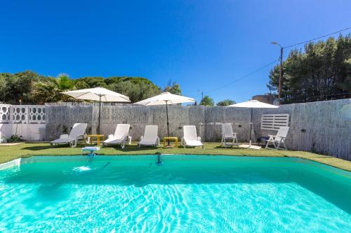 a swimming pool with chairs and umbrellas at Il Sole by BarbarHouse in Latiano