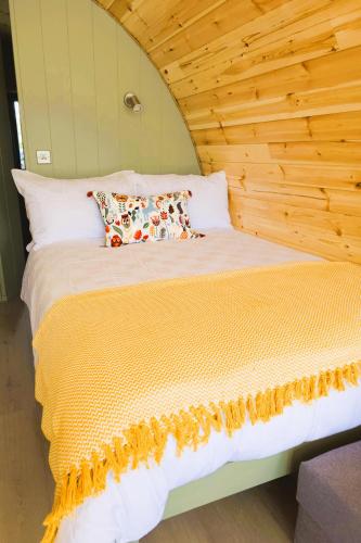 a bed with white sheets and pillows in a room at Nádúr Pods in Killarney, Co Kerry