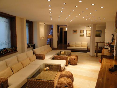 uma sala de estar com um sofá, cadeiras e uma mesa em Guest House Chicho Tsane em Bansko