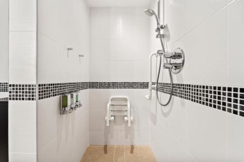 a shower in a bathroom with black and white tiles at Hampton by Hilton Cluj-Napoca in Cluj-Napoca