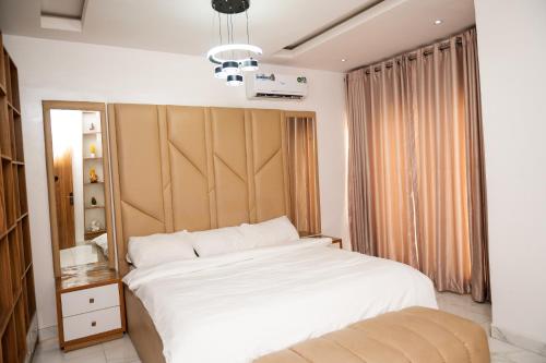 a bedroom with a large white bed and a window at 3bedroom duplex with ps5 in Ikate, lekki phase 1 in Lekki