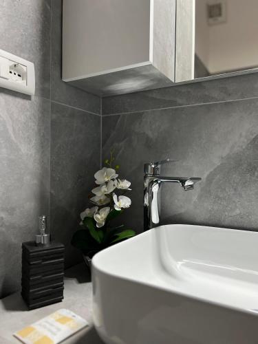 a bathroom with a white sink and a faucet at Harmony Affittacamere in Tortolì