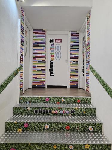a hallway with stairs with flowers in front of a door at Milano Ostello in Milan