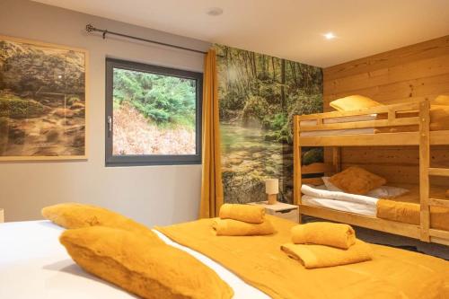 une chambre avec deux lits superposés et une fenêtre dans l'établissement Chalet Mont-Lac à 100m du Lac, à Gérardmer