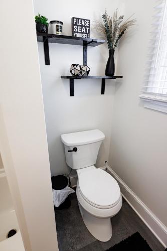 a bathroom with a toilet and a sign on the wall at The Cooper Home, Dogs Welcome! in Ephrata