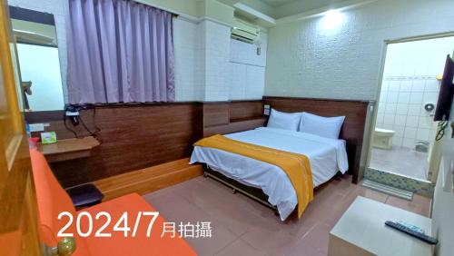 a hotel room with a bed and a bathroom at 安德飯店 in Green Island