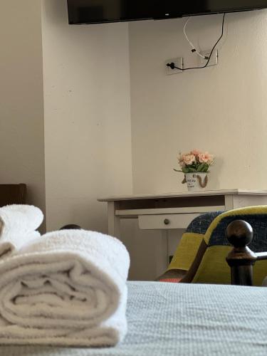 a room with a bed and a table with a towel at Harmony Affittacamere in Tortolì