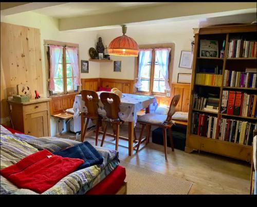 a living room with a table and chairs and bookshelves at Schell-Hütte in Preitenegg