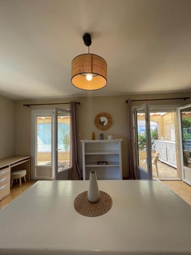 une salle à manger avec une table blanche et une lampe dans l'établissement L'air marin, à Sigean
