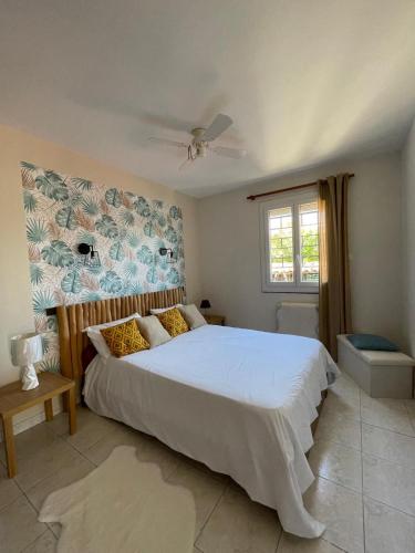 une chambre avec un grand lit blanc et une fenêtre dans l'établissement L'air marin, à Sigean