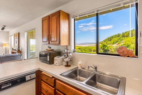 a kitchen with a sink and a large window at Finch's Sunset Condo #16 in Moclips