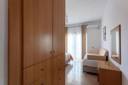 a bedroom with a large wooden cabinet and a bed at Zacharias apartments in Himare