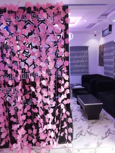 a room with a wall covered in pink flowers at City End Luxury Hotel and Apartments in Ikorodu