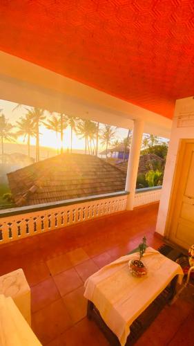 a room with a table and a large window at Paradise Inn Beach Resort in Varkala