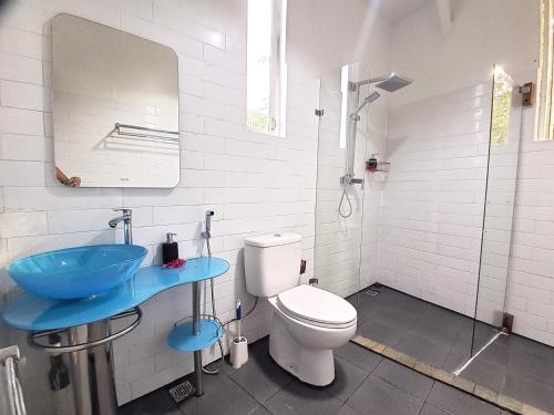 a bathroom with a toilet and a blue sink at Katara Gili, Boutique Rooms and Bungalows in Gili Trawangan