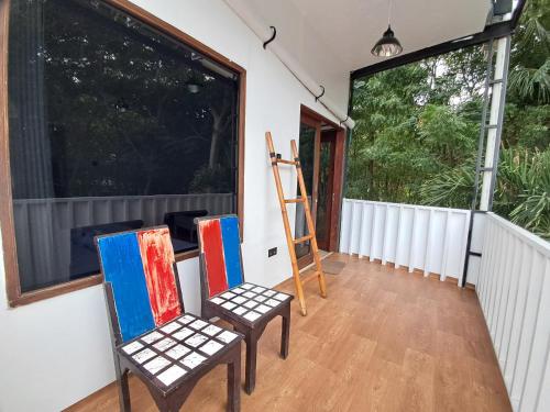 a room with two chairs and a ladder and a window at Katara Gili, Boutique Rooms and Bungalows in Gili Trawangan