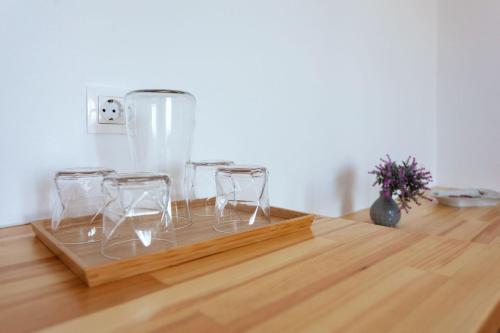 a wooden tray with three wine glasses on a table at Zacharias apartments in Himare