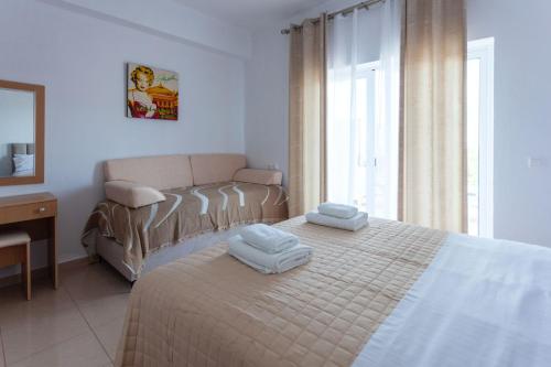 a bedroom with a bed with two towels on it at Zacharias apartments in Himare