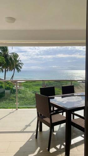 a table and chairs on a patio with a view of the ocean at B3 beautiful ocean view penthouse - Ocean Front in Cabarete