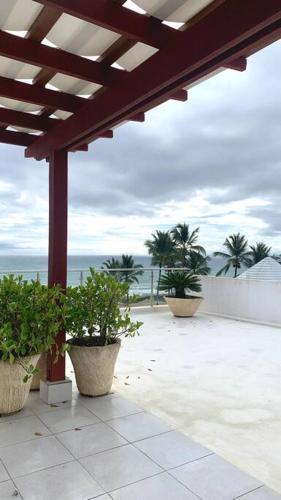a patio with three potted plants and the ocean at B3 beautiful ocean view penthouse - Ocean Front in Cabarete