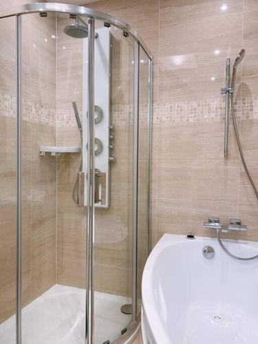 une salle de bain avec une douche, une baignoire et un lavabo dans l'établissement Paris cosy apartment 80m2, à Suresnes